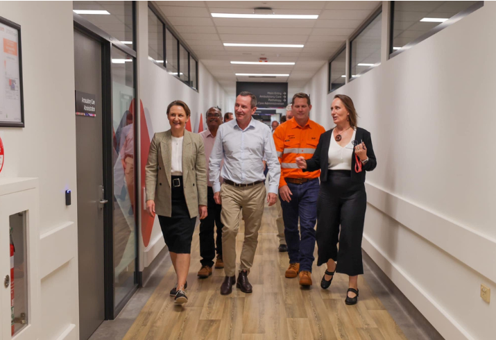 People walking down hospital corridor.