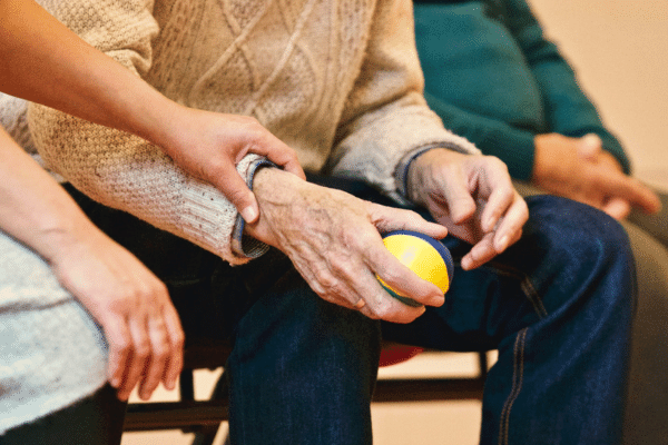 Aged care worker puts hand on the arm of elderly man