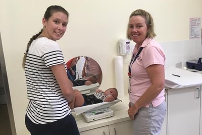 Child health nurse weighs baby