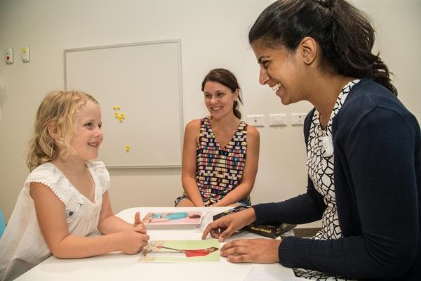 Speech pathologist reading with child 