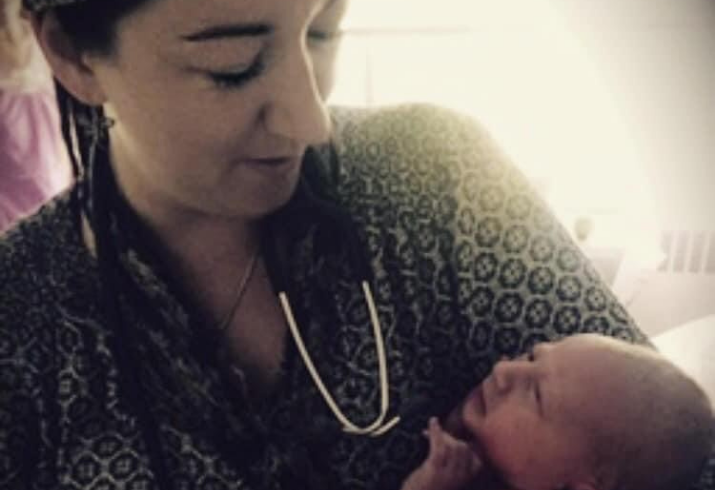 Midwife Kate Elliott cradles newborn baby