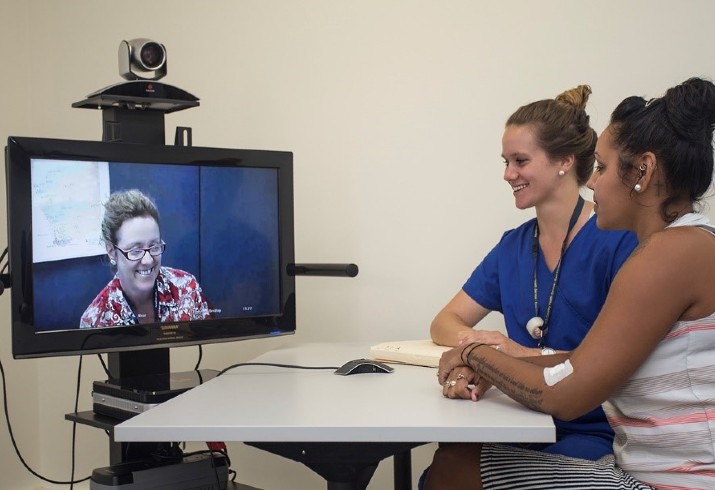 Clinicians talk with patient via telehealth 