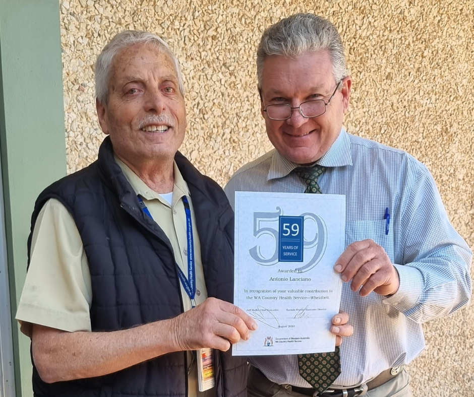 Two men stand together holding a certificate of service