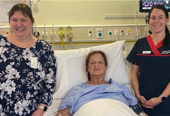 Patient in hospital bed surrounded by medical staff