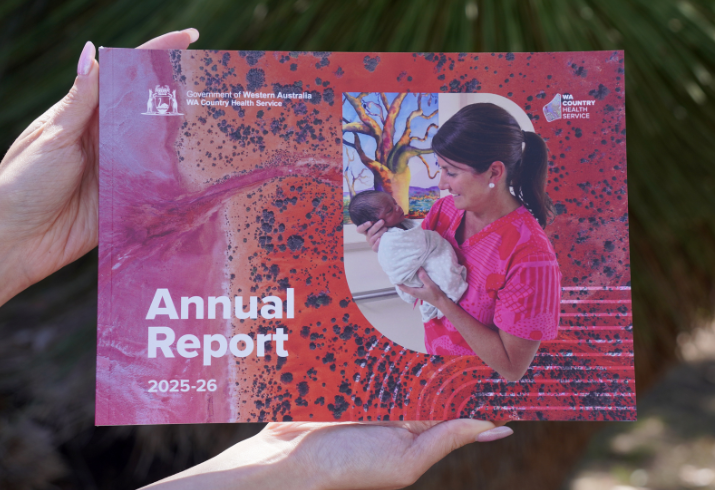 Hands holding the Annual Report 2025-26