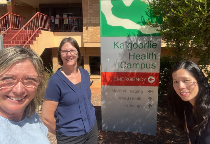 Three women stand in front of a hospital sign that says Kalgoorlie Health Campus