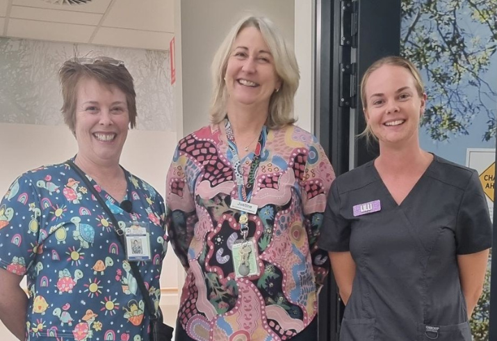 Three nurses in scrub tops.