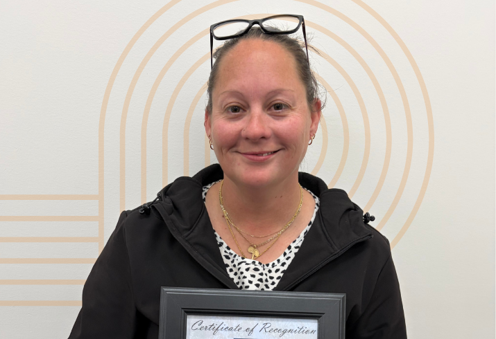 Woman holding certificate smiling.
