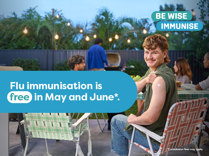 A man holds up his shirt sleeve showing a bandaid from having a recent injection , he is smiling and sitting in a  lawn chair in a backyard. A caption reads Flu immunisation is free in May and June.